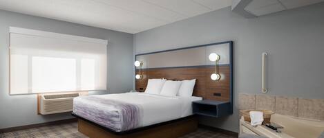 A hotel room with a bed, bedside table, lamp, and a bathroom with a bathtub and sink.