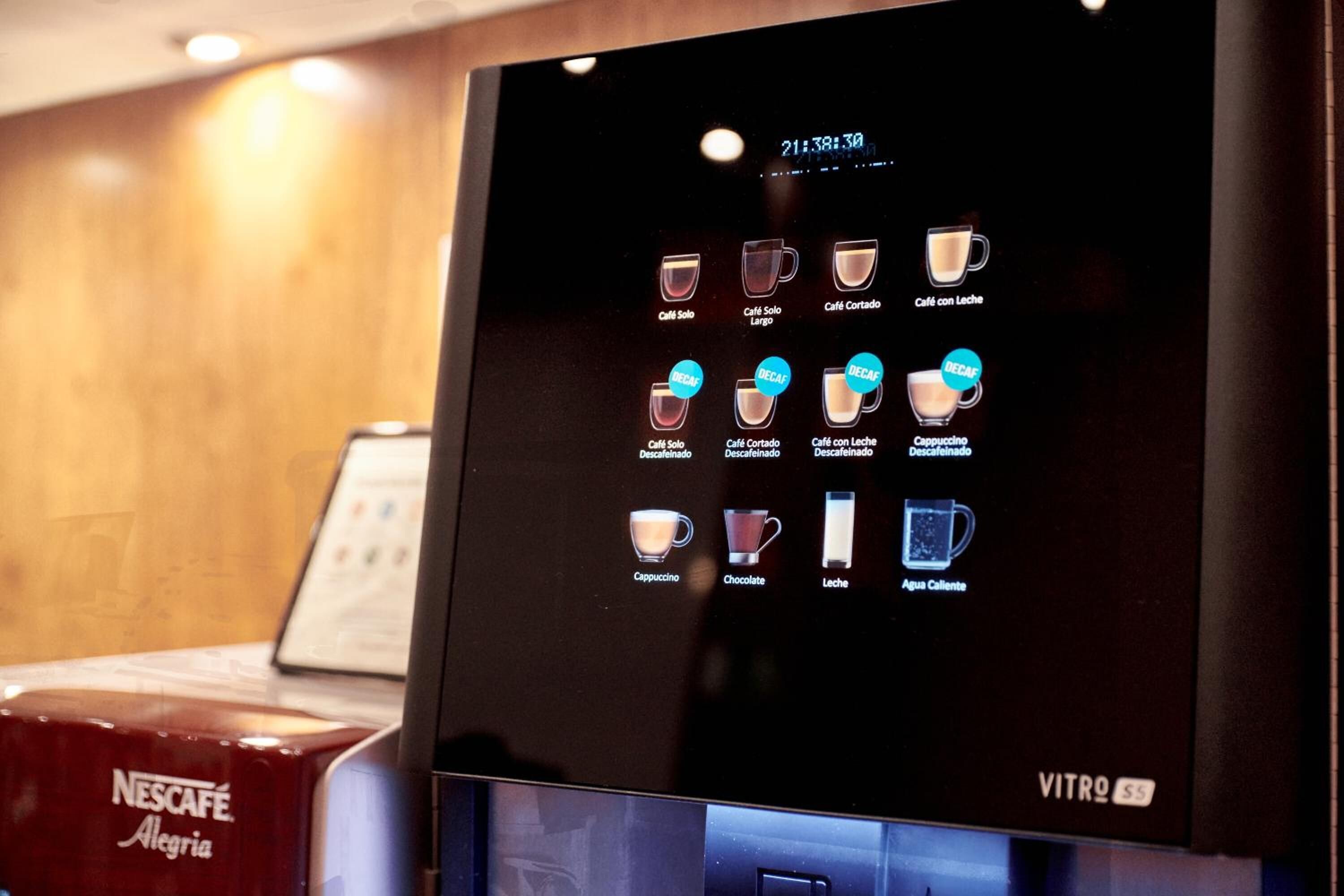 Een digitaal menuscherm van een Nescafé koffiemachine met diverse drankopties.