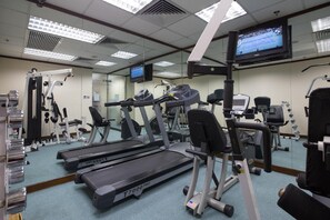 Work out in style with a fully equipped gym featuring treadmills, weightlifting equipment, and a large mirror.
