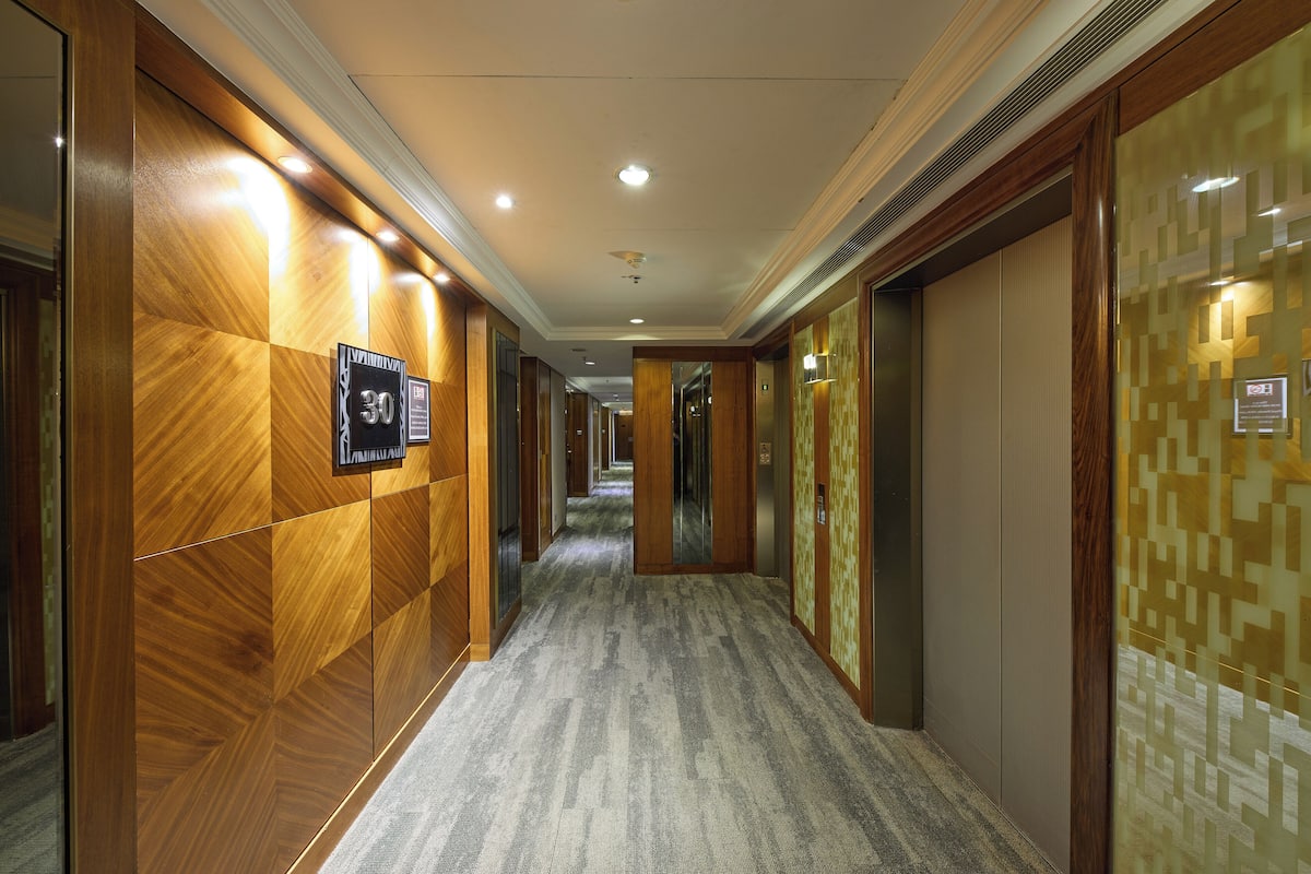 A hotel corridor with wooden paneling, a carpeted floor, and a sign indicating the 30th floor.