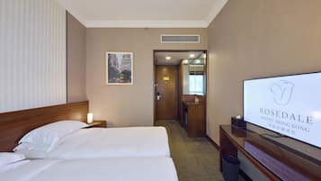 Una habitación de hotel con una cama, un televisor y un escritorio con una computadora.