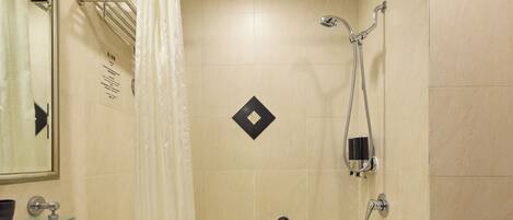 A modern bathroom with a bathtub, a shower, a sink, and a toilet.
