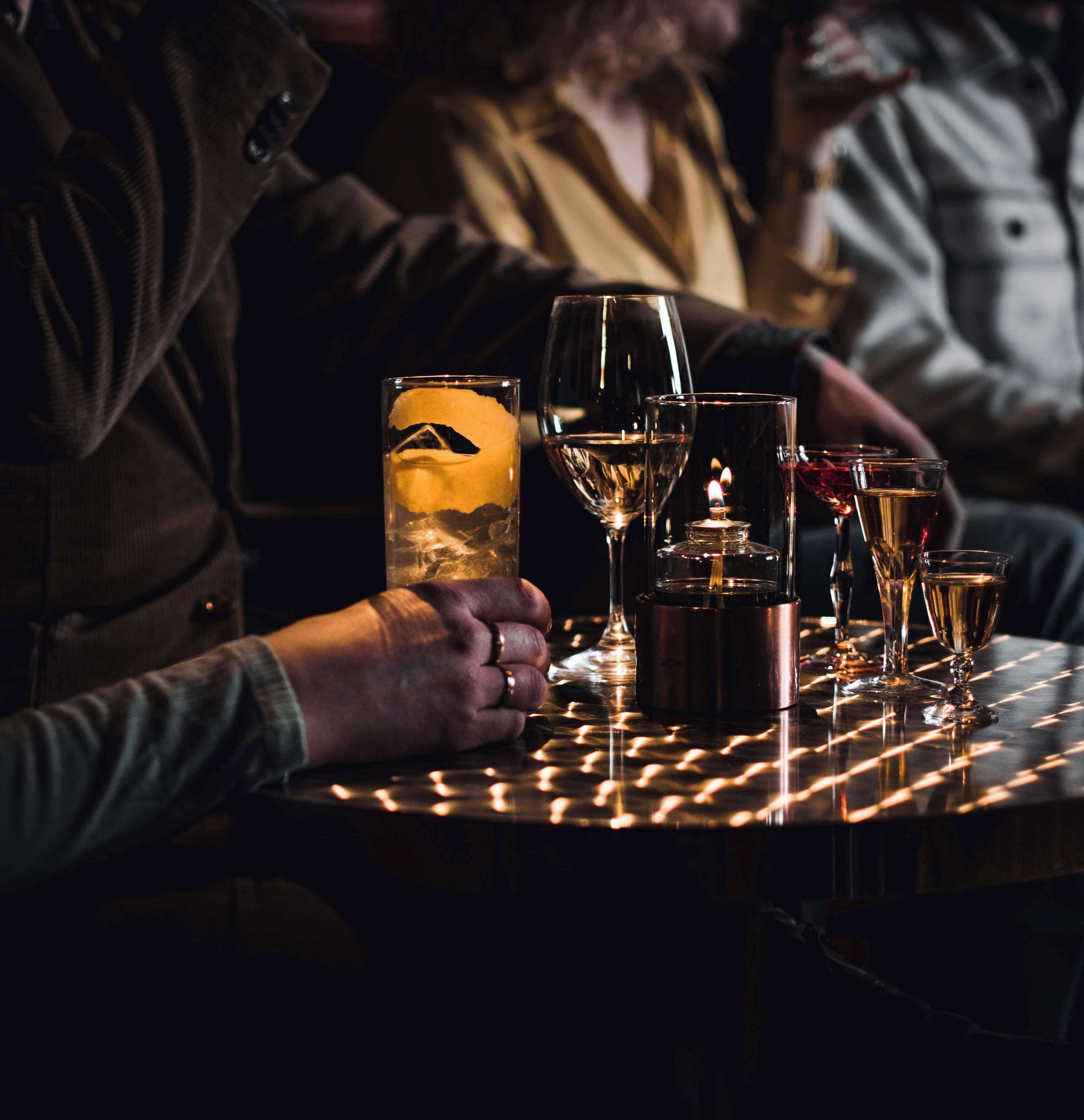Een tafel met verschillende glazen wijn en een kaars, wat wijst op een eettafel of gezellige setting.