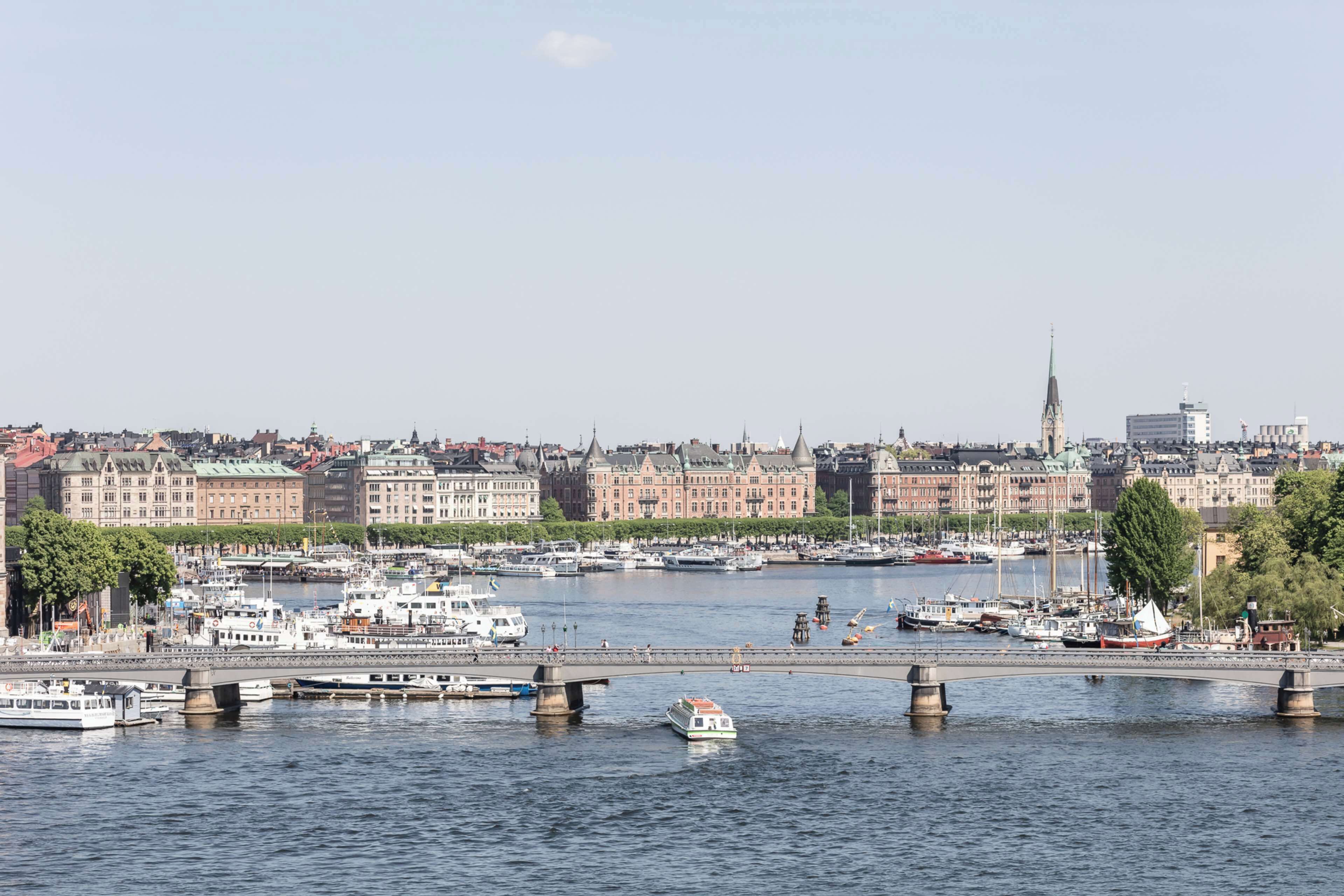 A river with boats, a bridge, and buildings in the background.