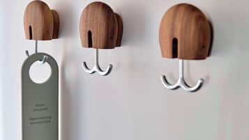 Ein an der Wand befestigter Holzhaken mit einem Metallschild, auf dem 'Zimmer besetzt' und 'Leide an Schreibblockade' steht, im HOTEL REISEN.