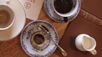 Una taula amb un menú, un quadern i diverses tasses de cafè.