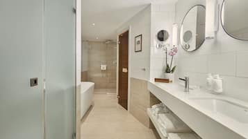 A modern bathroom with a large mirror, a bathtub, and a shower.