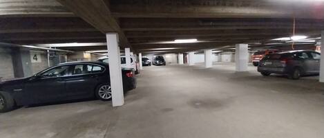 A multi-level parking garage with concrete pillars and overhead lighting.
