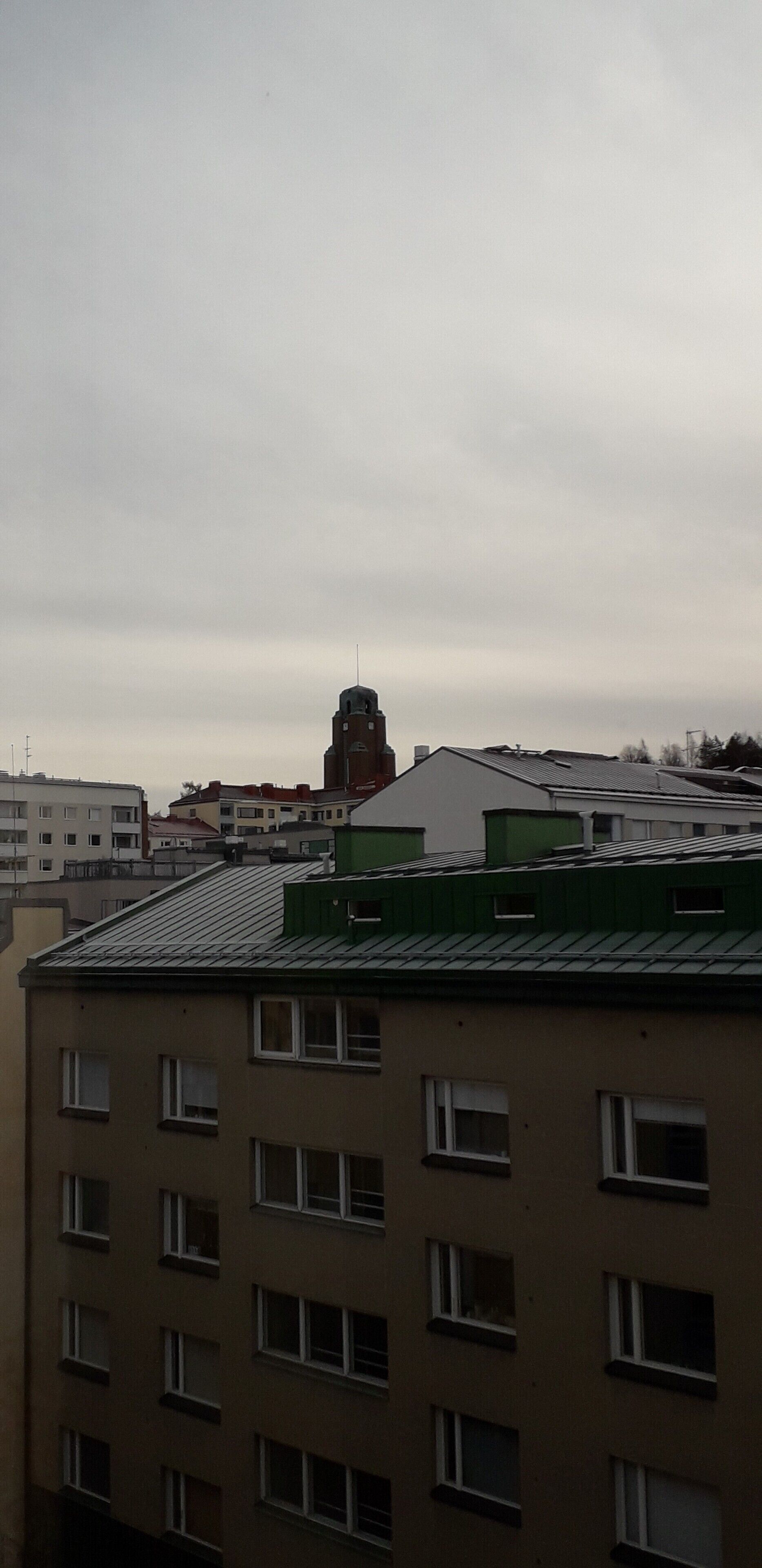 A multi-story building with a flat roof and several windows.