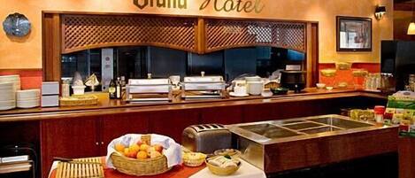 A buffet setup in a Grand Hotel with a variety of food items and a coffee machine.