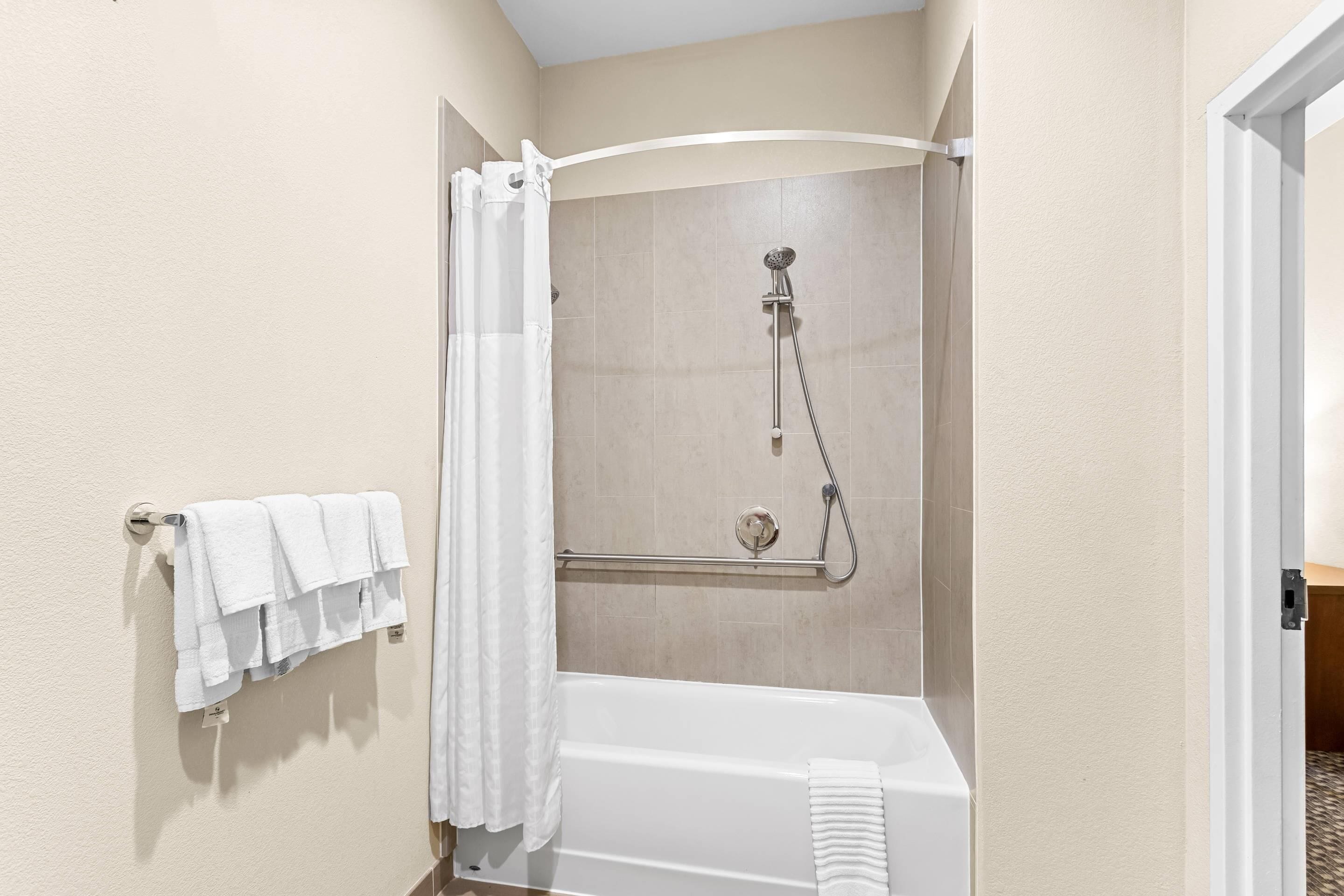 Un baño con bañera, ducha y perchero para toallas.