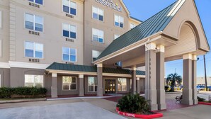 A hotel with a modern facade, a covered entrance, and a clear sky. - Sonesta Essential IAH Airport JFK Boulevard (Houston)