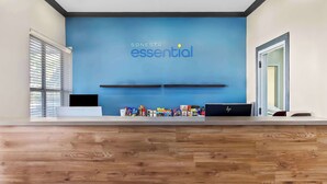 A reception desk with a blue wall and the text "SONESTA essential" above it. - Sonesta Essential IAH Airport JFK Boulevard (Houston)