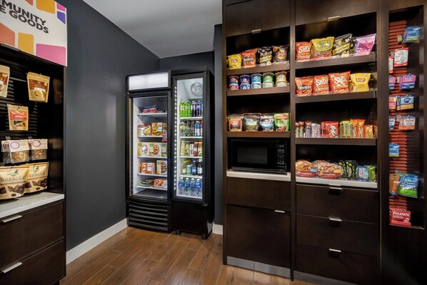 A grocery store interior with shelves stocked with snacks, beverages, and packaged goods.