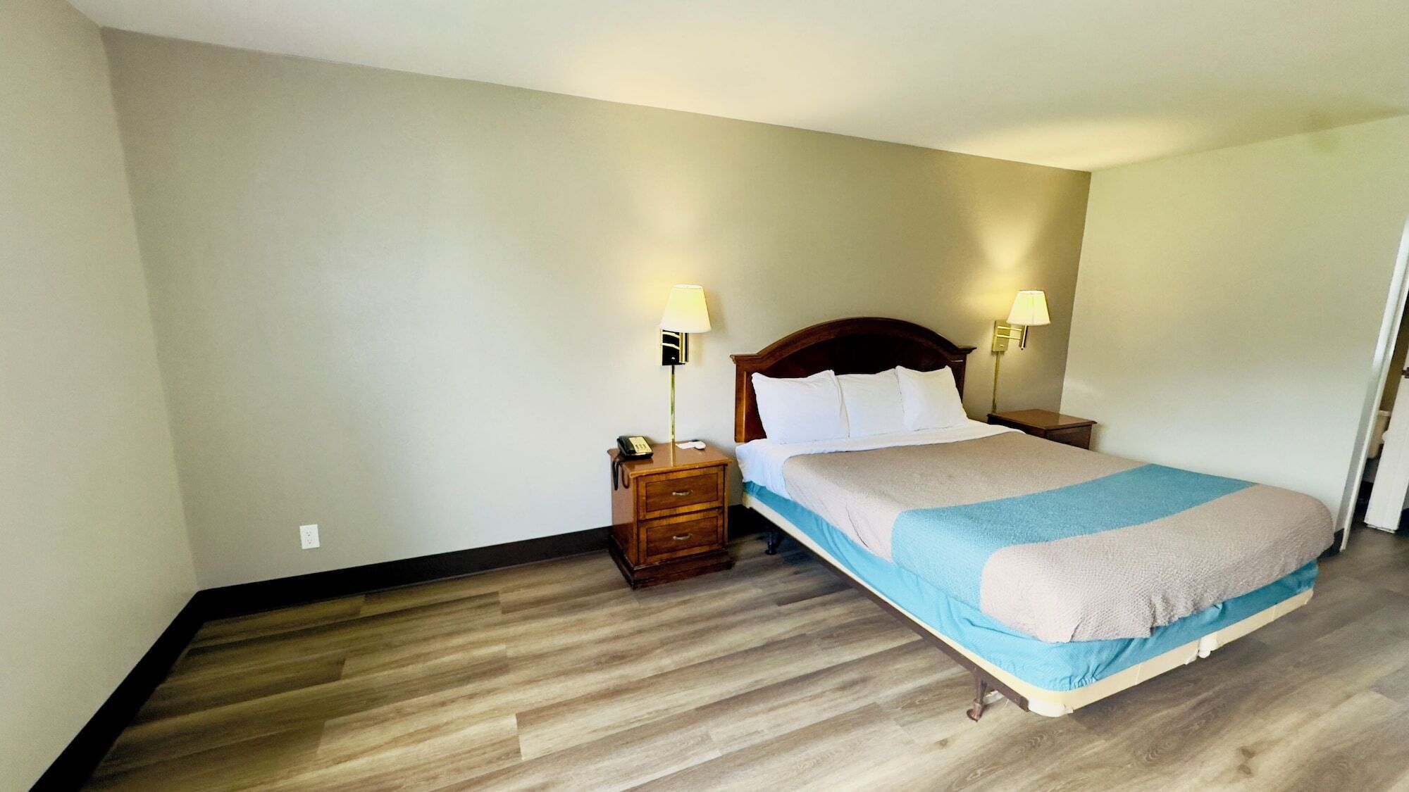 Habitació d'hotel amb un llit, dues taules de nit i una petita taula auxiliar.