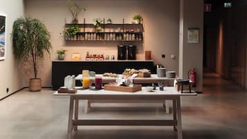 Una mesa con productos para el desayuno y una estación de café en un ambiente moderno.