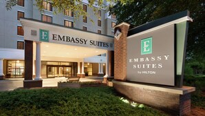 The exterior of Embassy Suites by Hilton, featuring a prominent entrance with a large sign, columns, and a well-maintained garden area. - Embassy Suites by Hilton Atlanta Alpharetta (Alpharetta)