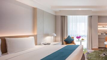 A modern hotel room with a large bed, a desk, a chair, and a view of the city.