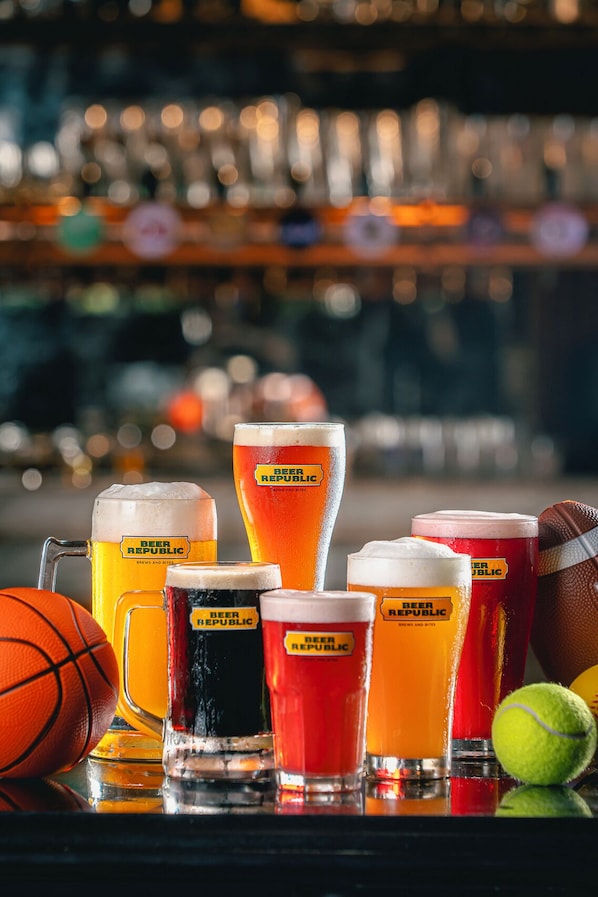 A bar setting with various beer mugs and sports balls.