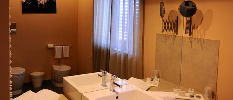 A hotel bathroom with two sinks, a large mirror, and a towel rack.