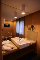 Un bagno d'albergo con due lavandini, uno specchio grande e un porta asciugamani.