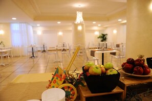 Enjoy meals in this inviting dining area with a central table, comfortable chairs, and a beautiful potted plant.