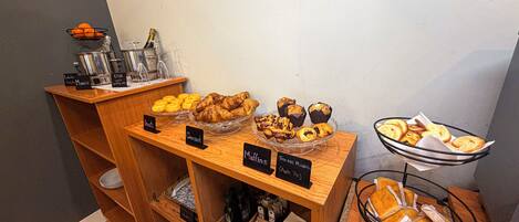 A buffet with various baked goods and a coffee station.