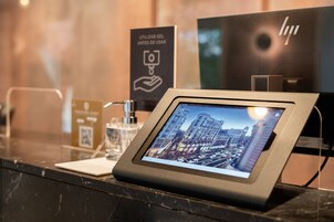 Ein digitales Kiosk mit Stadtansicht, einem QR-Code und einem Handdesinfektionsspender.