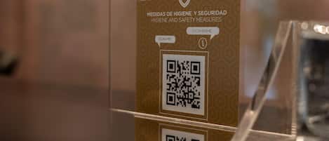 A QR code on a sign with hygiene and safety measures.