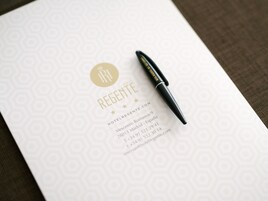 Eine Hotelbroschüre mit dem Namen "Regente" und Kontaktinformationen, darunter Adresse, Telefonnummer und Webseite.