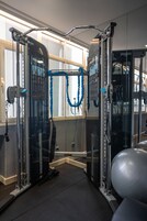 A gym with exercise equipment, a pull-up bar, and a weight ball.