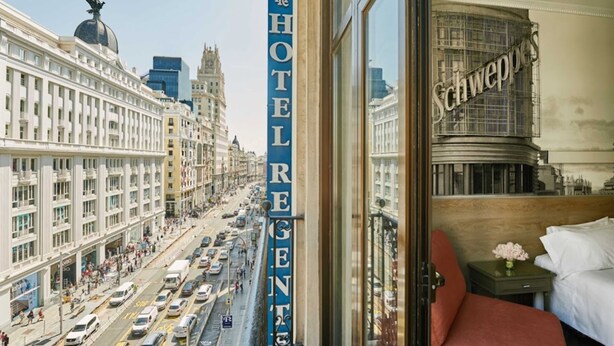 A hotel interior with a view of a busy street outside. - Hotel Regente (Madrid)