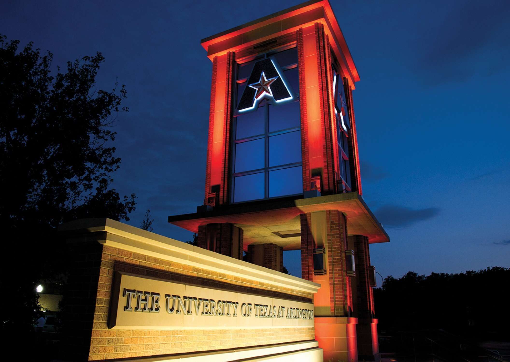 Una torre con una estrella en la cima, con la leyenda 'The University of Texas at Arlington'.