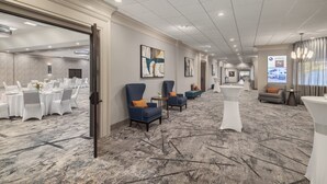 A spacious hotel lobby with a marble floor, seating areas, and a reception desk. - Holiday Inn Wichita East I-35 by IHG (Wichita)