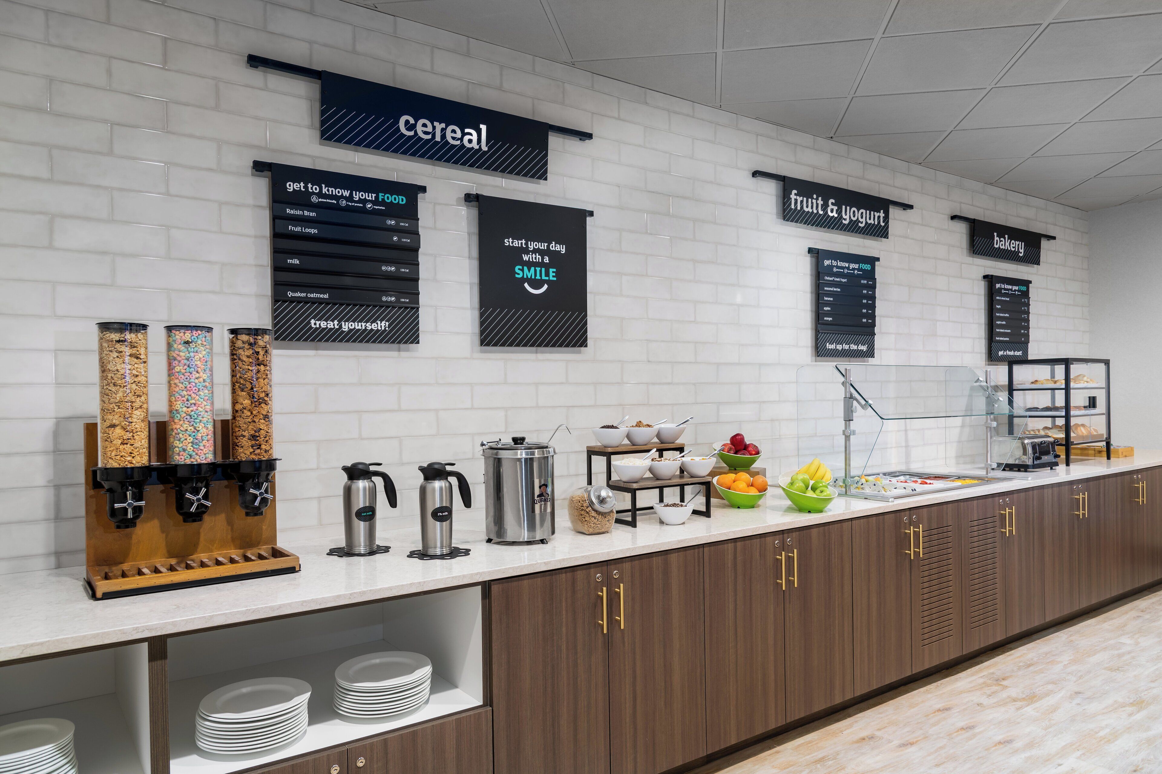 Un buffet pour le petit-déjeuner proposant des céréales, des fruits et des yaourts, ainsi qu’un choix de produits de boulangerie.