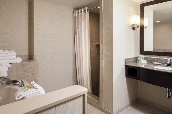 A modern bathroom with a shower, a sink, and a mirror.