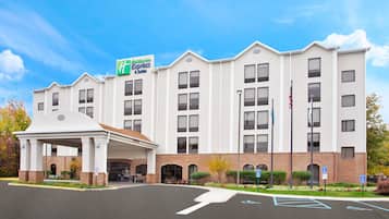 Un hotel de varios pisos con un letrero llamativo de Holiday Inn Express & Suites.