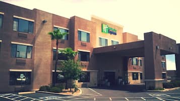 A Holiday Inn Express hotel with a modern design, featuring a large parking lot and a covered entrance.