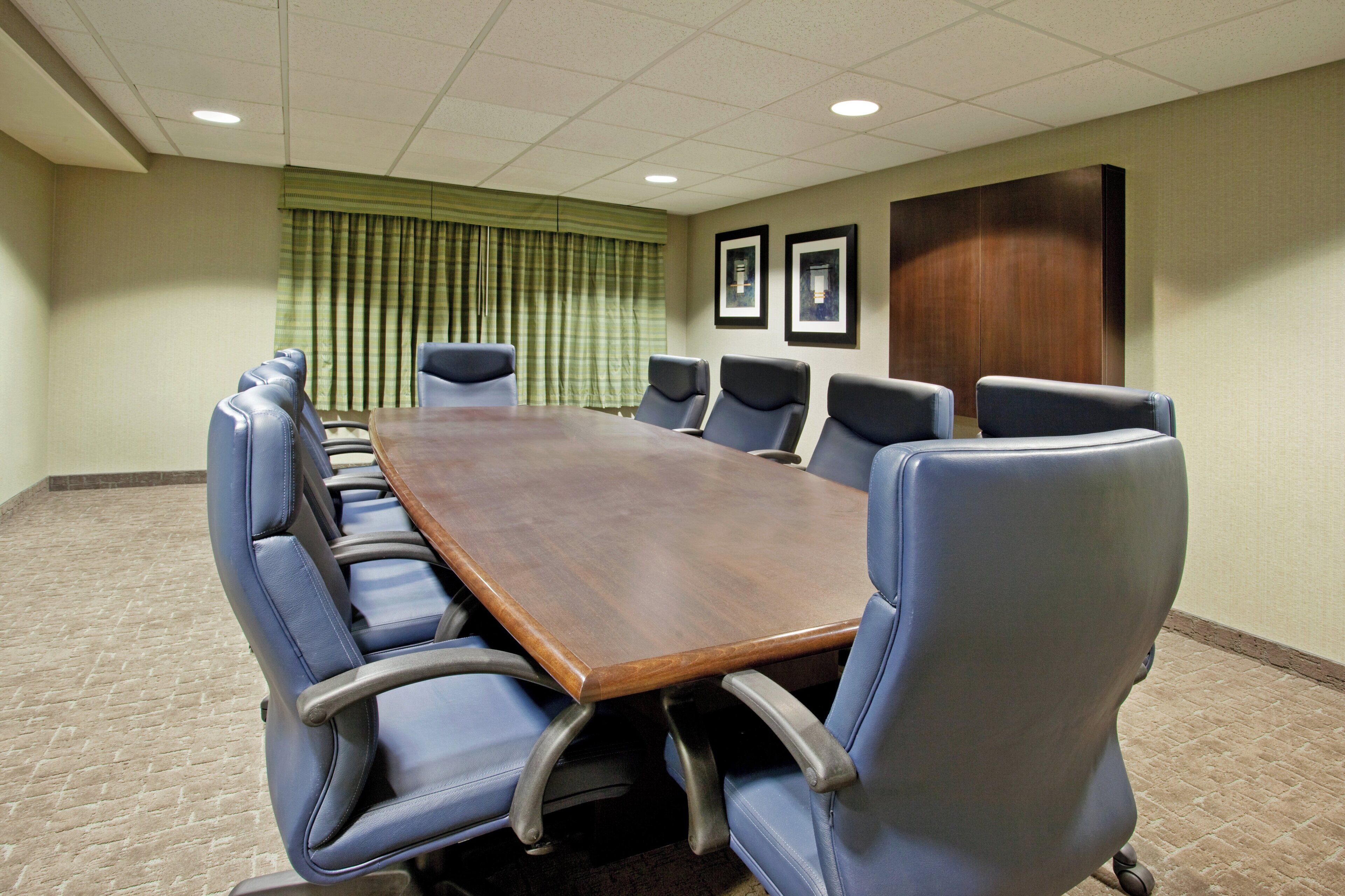 A conference room with a long table and eight chairs.