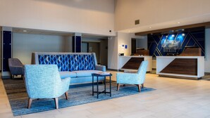 A modern lobby with a sofa, two armchairs, a small table, and a reception desk. - Holiday Inn Express & Suites Nogales by IHG (Nogales)