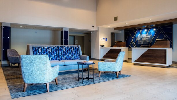 A modern lobby with a sofa, two armchairs, a small table, and a reception desk. - Holiday Inn Express & Suites Nogales by IHG (Nogales)