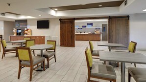 A modern hotel lobby with a reception desk, seating area, and a coffee bar. - Holiday Inn Express & Suites Orangeburg by IHG (Orangeburg)