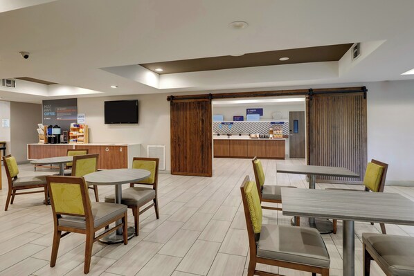 A modern hotel lobby with a reception desk, seating area, and a coffee bar. - Holiday Inn Express & Suites Orangeburg by IHG (Orangeburg)