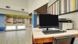 A reception desk with a computer, a printer, and a chair. - Holiday Inn Express & Suites Orangeburg by IHG (Orangeburg)