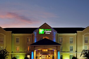 Un hotel Holiday Inn Express & Suites con un letrero destacado, una entrada central y una fachada simétrica.