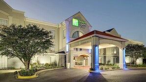 A Holiday Inn Express & Suites building with a clear entrance, a covered waiting area, and a landscaped garden. - Holiday Inn Express & Suites Orangeburg by IHG (Orangeburg)