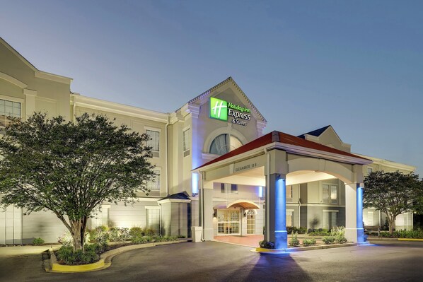 A Holiday Inn Express & Suites building with a clear entrance, a covered waiting area, and a landscaped garden. - Holiday Inn Express & Suites Orangeburg by IHG (Orangeburg)