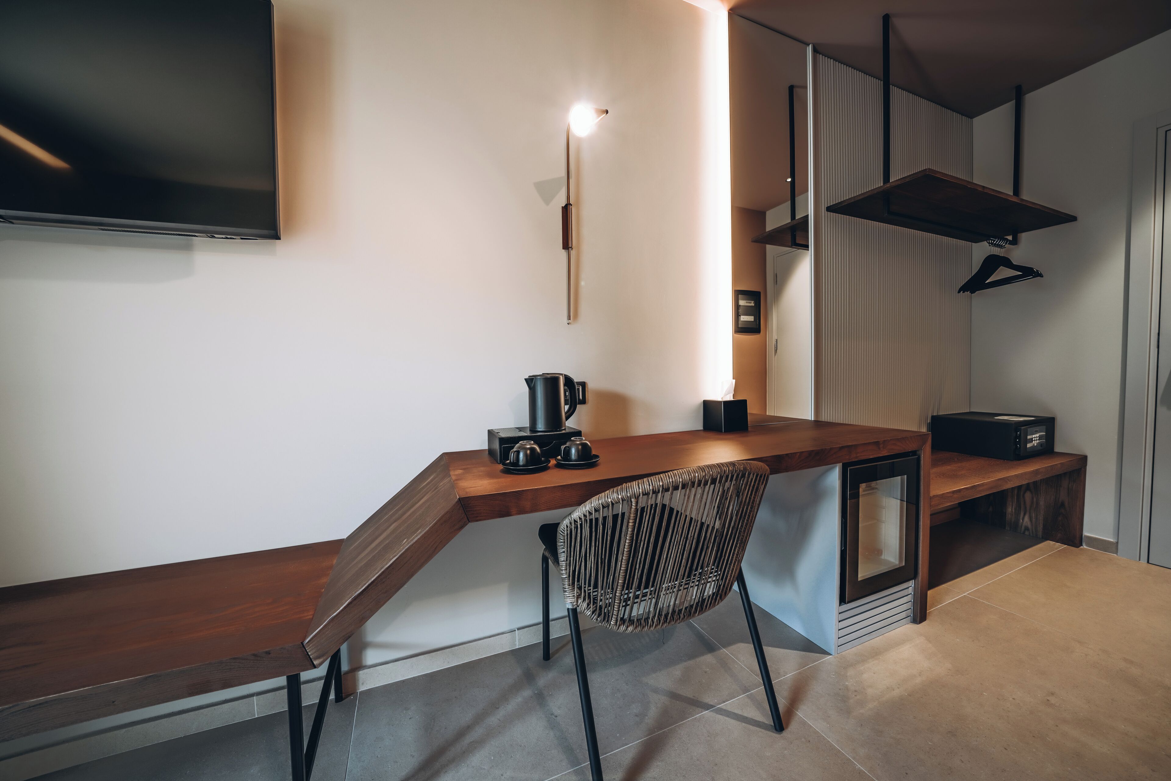 Une cuisine moderne avec un plan de travail en bois, une cuisinière encastrée et un luminaire suspendu.