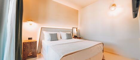 A neatly arranged hotel room with a large bed, bedside tables, and a wall-mounted light fixture.