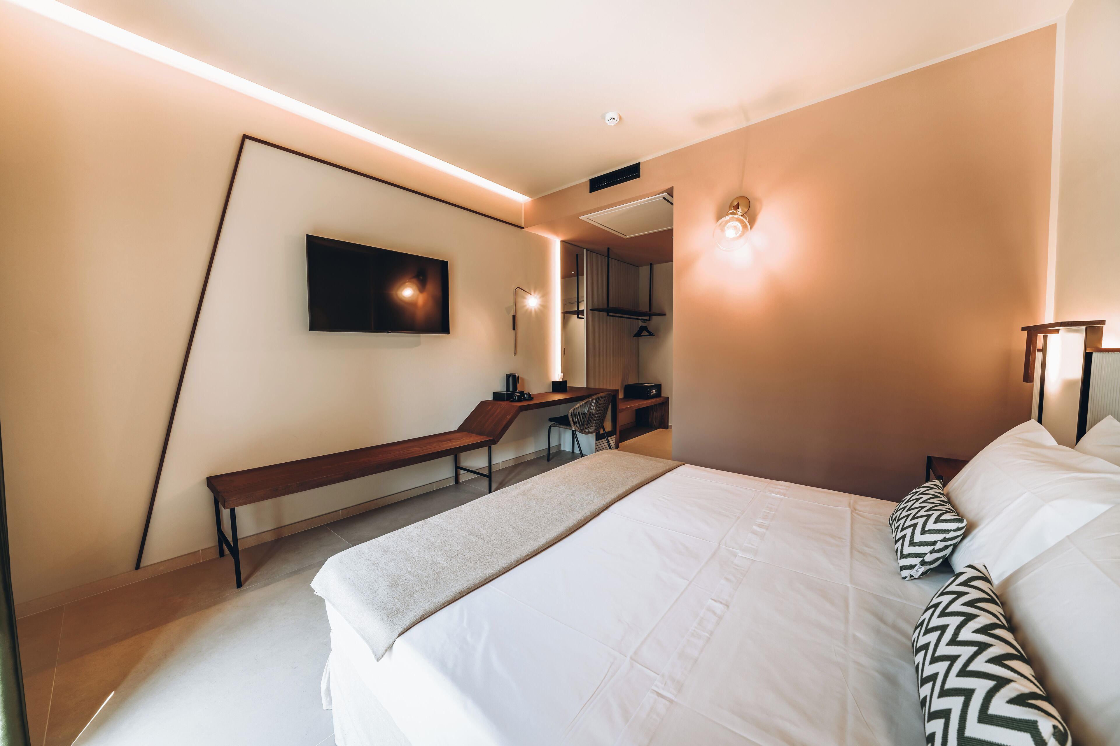 Ein modernes Hotelzimmer mit einem großen Bett, einem Schreibtisch und einem Stuhl.